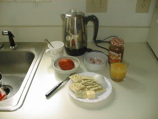 休日の朝食、クラッカーにバターとジャム、トマト、ソーセージ
